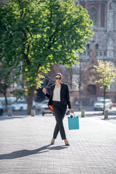 Стильна темноволоса жінка з сумками на вулиці
 - Фото, зображення