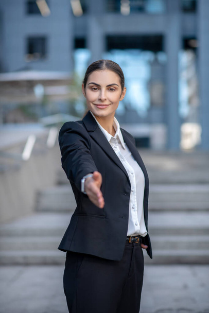 Elegant woman in a suit stretching her hand in greeting - Foto, immagini