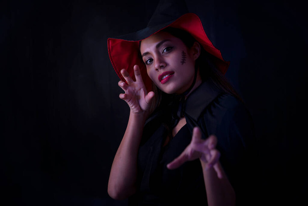 Young brunette woman in black hat and costume, Attractive thai asia female model. Halloween Portrait of attractive with red lipstick - Valokuva, kuva