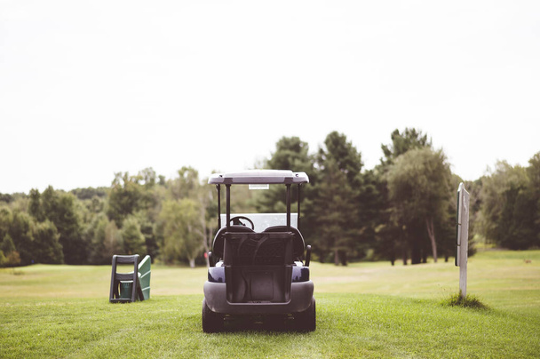 A closeup focus shot of a golf cart parked on a field - Fotoğraf, Görsel