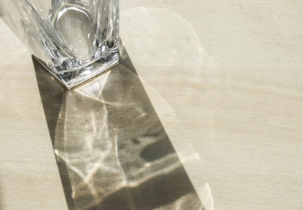 A glass jar leaving reflections on the ground covered by the sunlight - Fotoğraf, Görsel