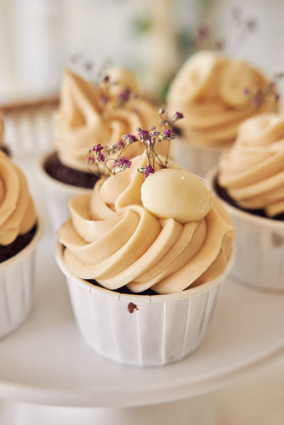 A selective focus shot of delicious chocolate cupcakes with white cream topping - Fotoğraf, Görsel