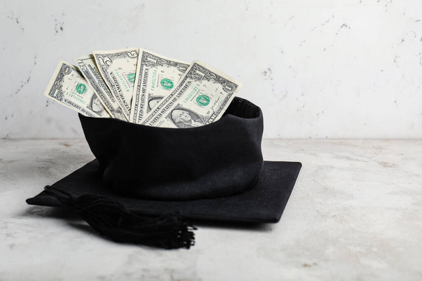 Sombrero de graduación con dinero en la mesa. Concepto de tasas - Foto, Imagen