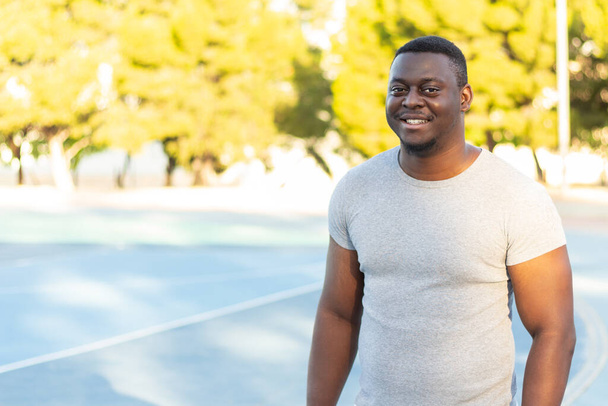 A portrait of a young black smiling male in a sunny park in Alicante, Spain - Foto, imagen