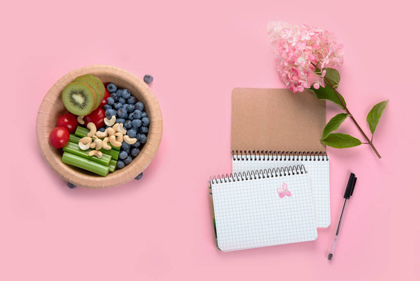 Healthy vegetarian lunch. Berries, fruits and vegetables. Healthy concept with nutrition food. Office desk table with spiral notebook. Top view, flat lay, copy space - Foto, immagini