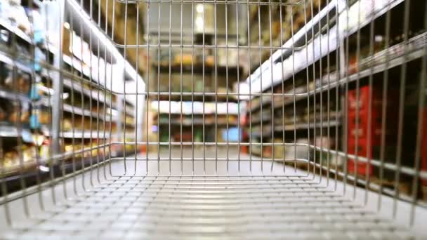 Movimiento lento del carrito de compras que se mueve a través de la tienda  - Metraje, vídeo