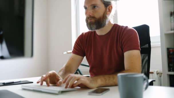 Freelancer homem trabalhando a partir de sua mesa de escritório em casa - Filmagem, Vídeo