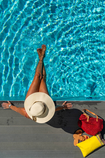 woman with straw hat in luxury five stars  spa resort by the swimming pool.  - Foto, Imagen
