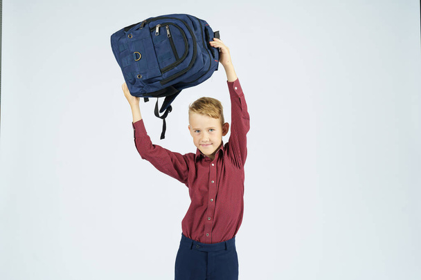 A schoolboy holds a schoolbag over his head. Education concept - Foto, immagini