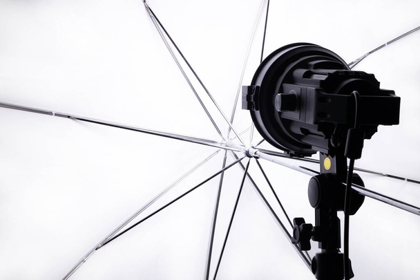 スタンド、クローズアップに取り付けられた白い傘とプロのスタジオスポットライト - 写真・画像