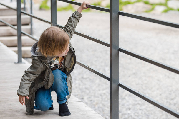 Small child holds on to the railing - Foto, afbeelding