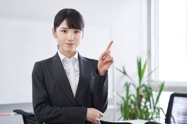 Одна японська жінка в своєму офісі вказує на японську комерсантку. - Фото, зображення
