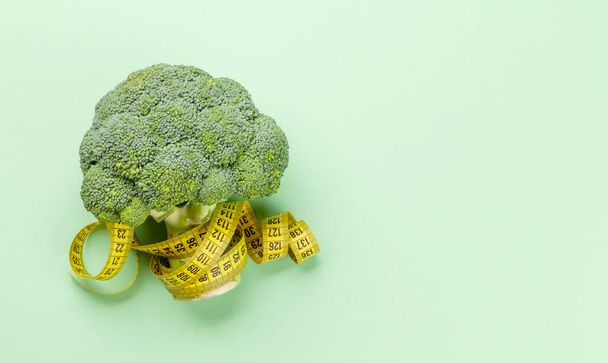 Broccoli e metro a nastro. Cibo sano e pesare concetto di perdita. Dieta e fitness. Vista dall'alto posa piatta con spazio di copia - Foto, immagini