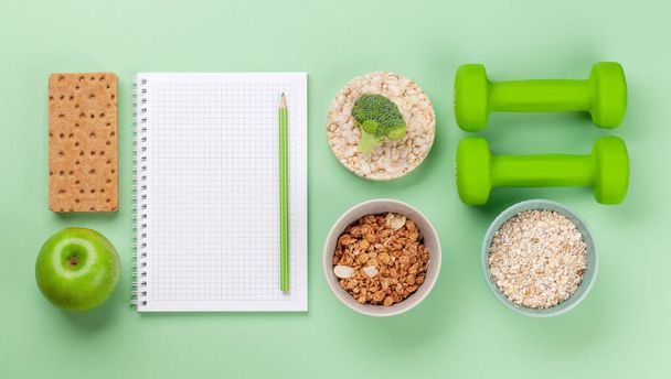 Healthy food and weigh loss concept. Top view flat lay with notepad for your fitness or diet plan - Photo, Image