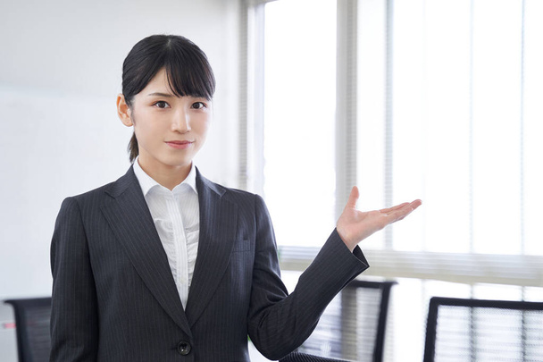 Egy japán nő körbevezet egy japán üzletasszonyt az irodában. - Fotó, kép