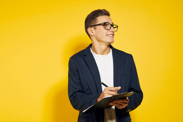 business man at work wearing glasses and a jacket on a yellow background talking on the phone employee model - Photo, Image