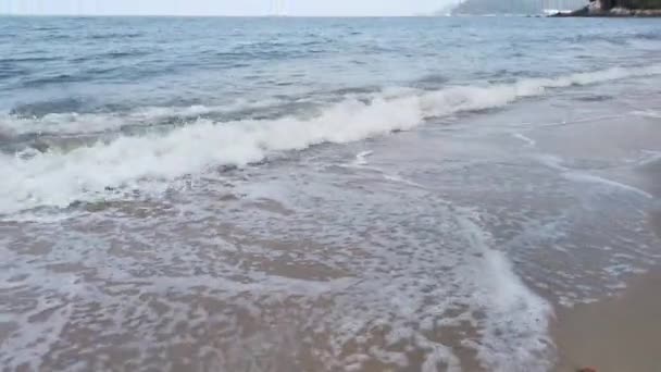 Gündüz sahnesi deniz yükseldiğinde kumlu kumsalda dalgalar hareket ederken - Video, Çekim