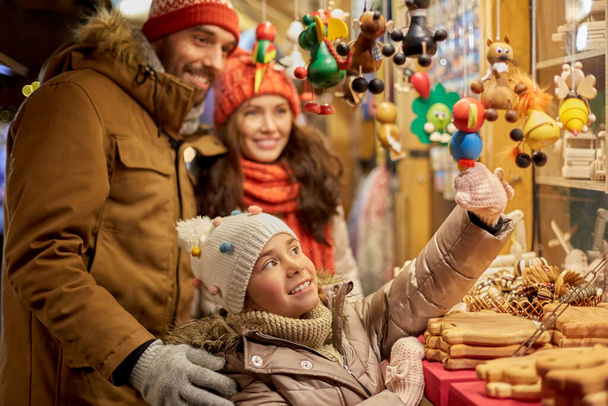 happy family buying souvenirs at christmas market - 写真・画像