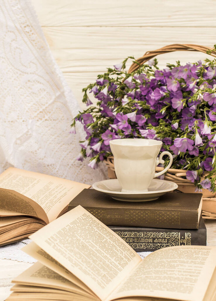 tazza di caffè (tè), libri e lino bouquet in cesto di vimini. Stile retrò, vintage - Foto, immagini