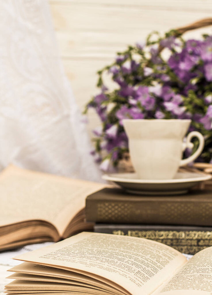 šálek kávy (čaj), knihy a kytici lnu v proutěném košíku. Retro styl, vintage - Fotografie, Obrázek