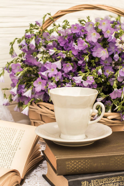 カップコーヒー(お茶)本や花束をウィッカーバスケットに入れます。レトロなスタイル、ヴィンテージ - 写真・画像