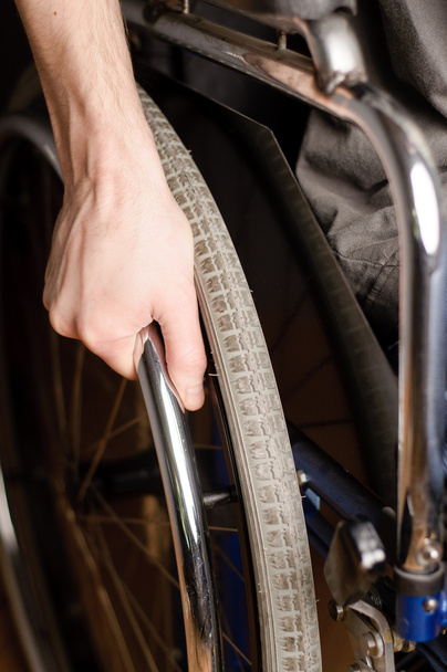 Close-up of male hand on wheel of wheelchair - 写真・画像