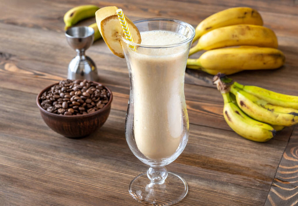 Szklanka brudnego koktajlu bananowego ze składnikami na drewnianym tle - Zdjęcie, obraz