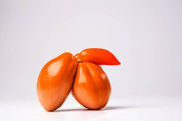 Hauska eroottinen tomaatti kevyellä taustalla. - Valokuva, kuva