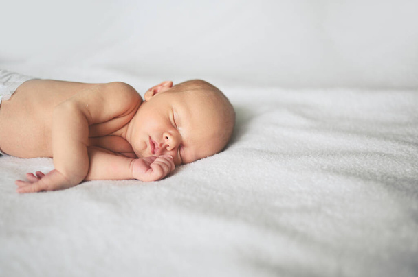 Cute emotional funny newborn little baby boy sleeping in crib. Baby goods packaging template. Healthy child, concept of hospital and happy motherhood. Infant baby. Nursery. - Фото, зображення