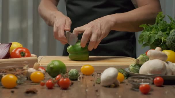 Professional chef prepares and cuts green bell pepper. Close up slow motion - Footage, Video