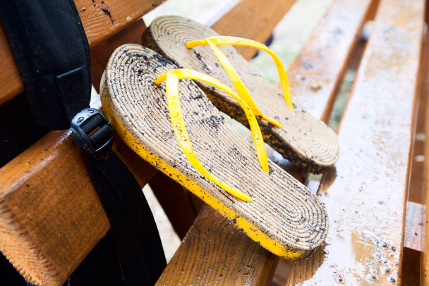 mokre letnie pantofle na ławce po letnim deszczu   - Zdjęcie, obraz