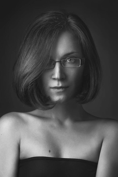 portrait of the beautiful young girl wearing spectacles. it is tinted in brown color - Photo, Image