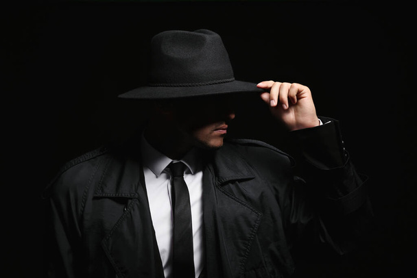 Old fashioned detective in hat on dark background - Фото, изображение
