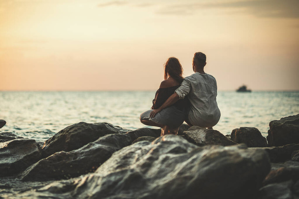 Una coppia amorevole si sta divertendo e si abbraccia sulla spiaggia sabbiosa vuota al tramonto.. - Foto, immagini