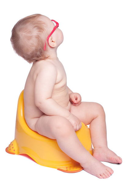 bebezinho com óculos sentados na sanita e olhando para cima. isolado em branco - Foto, Imagem