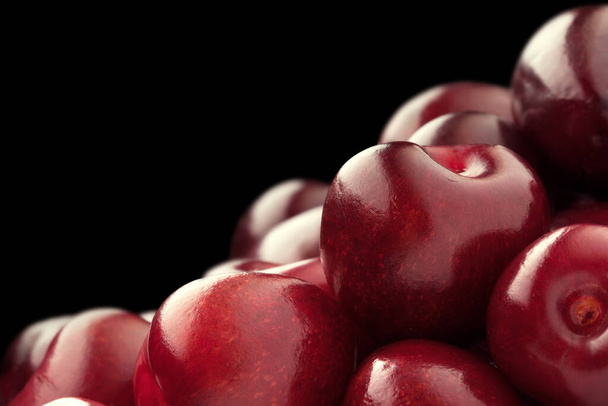 background of a handful of red ripe sweet cherry. isolated on black - Zdjęcie, obraz