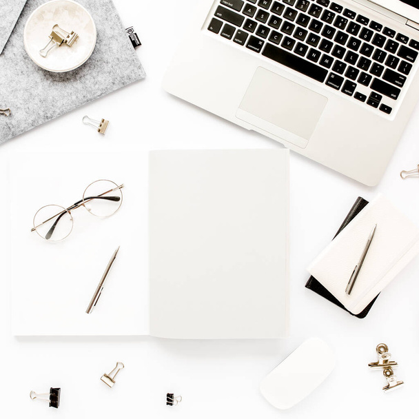 Home office workspace frame with laptop, clipboard, notebook and accessories on white background. Flat lay, top view - 写真・画像