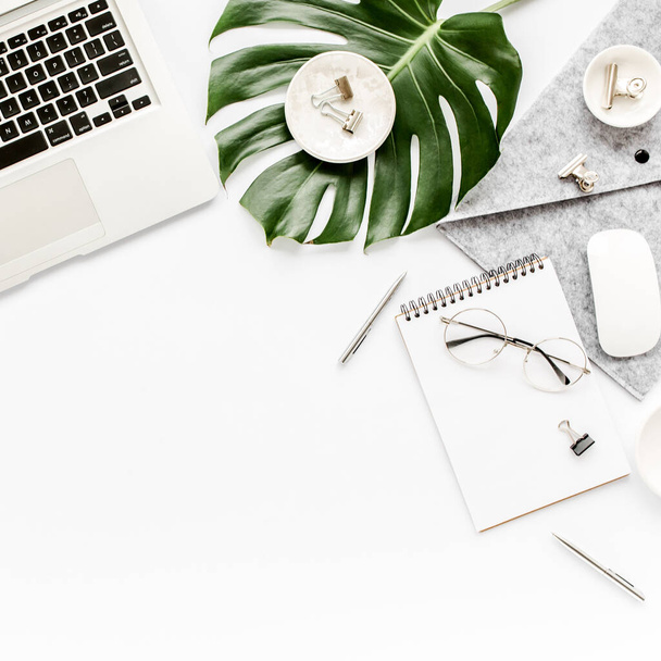 Home office workspace mockup with laptop, tropical leaves Monstera, clipboard, notebook and accessories on white background. Flat lay, top view - Φωτογραφία, εικόνα