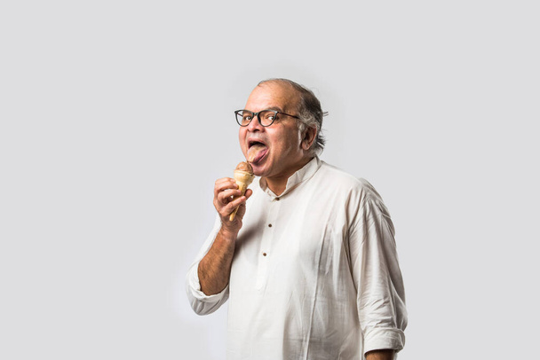 Indian Old man die chocolade eet IJs in kegel of mango snoepreep - Foto, afbeelding
