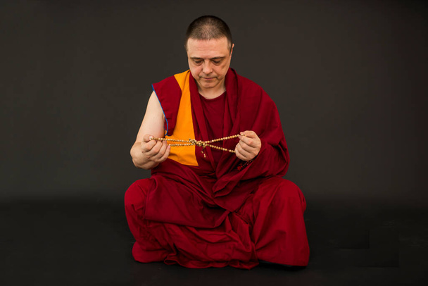 Монах держит четки в руке - Фото, изображение