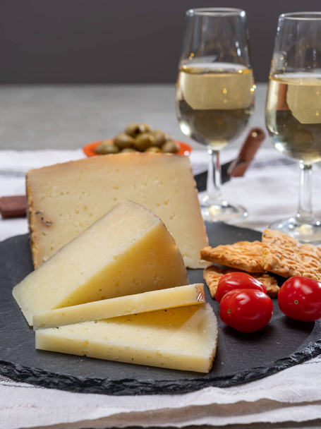 Španělské tapas, sýr manchego, zelené olivy podávané se sklenicemi suchého fino sherry vína zblízka - Fotografie, Obrázek
