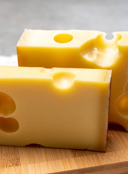Блокування швейцарського середнього твердого жовтого сиру випромінювач або емменталізатор з круглими отворами закриті вгору - Фото, зображення