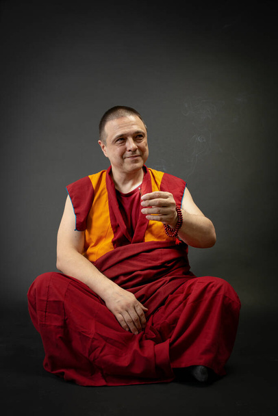 Monge budista segurando uma vara de incenso fumante em sua mão - Foto, Imagem