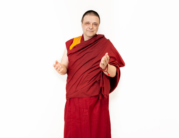 Porter of a Tibetan Mongolian monk in ritual red clothing on a white background - Photo, Image