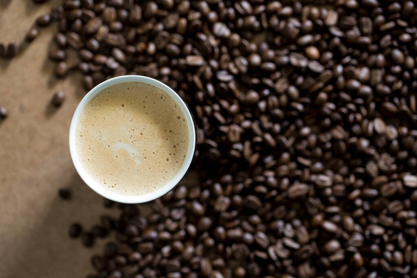 Xícara de café cercada por grãos de café - Foto, Imagem