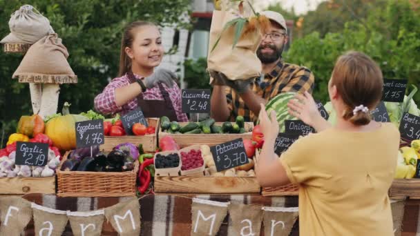 Cliente femenino comprando comestibles orgánicos en el mercado de agricultores - Metraje, vídeo