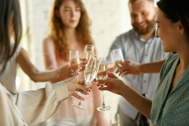 ワインやシャンパンでグラスをクリックする人。幸せな陽気な友人は、会議の休日を祝う。笑顔の友人のショットを閉じる,ライフスタイル - 写真・画像
