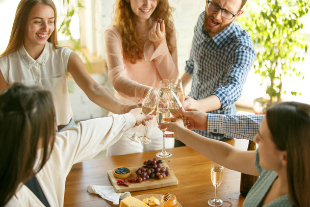 People clinking glasses with wine or champagne. Happy cheerful friends celebrate holidays, meeting. Close up shot of smiling friends, lifestyle - Φωτογραφία, εικόνα