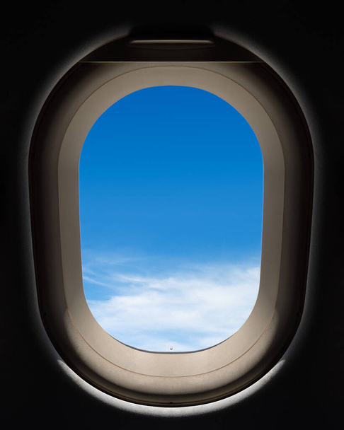 Окно самолета с видом на голубое небо над облаками - Фото, изображение