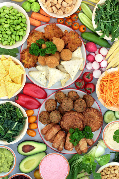Gezondheidsvoedsel voor een voedzaam veganistisch dieet, met op planten gebaseerde hamburgers, worsten, ballen, samosas & ui bhaji 's met groenten, dips, peulvruchten en snacks. Hoog gehalte aan eiwitten, mineralen, vitaminen en antioxidanten. - Foto, afbeelding